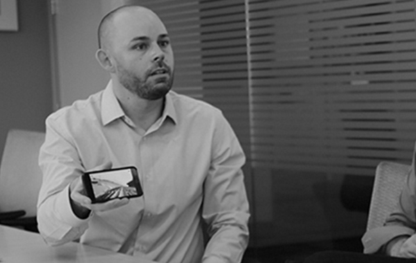 A developer at a meeting shows the attendees content on a mobile device