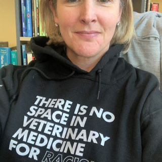 An employee wearing a hoodie that says 'There is no space in veterinary medicine for racism'