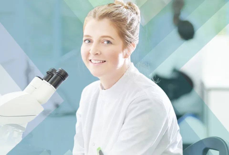 A woman in a lab coat analyzing data on a computer screen.