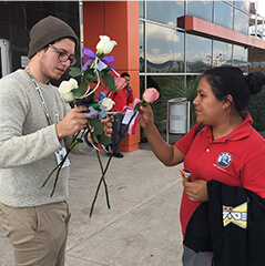 Joven está repartiendo rosas a una mujer