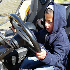 Un niño con las manos en un volante