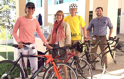 Four employees standing behind their bike.