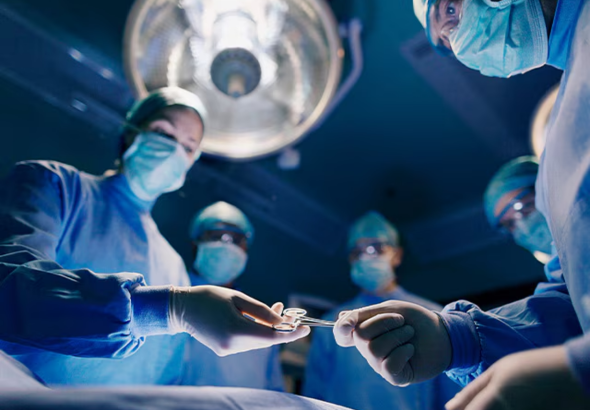 Someone wearing gloves passing surgical scissors to someone else in gloves