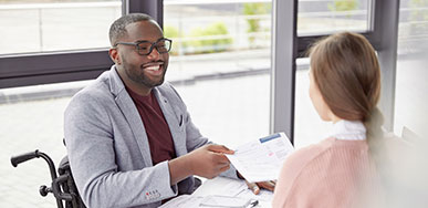 Man in wheelchair smiling with coworker