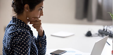Woman thoughtful in front of laptop