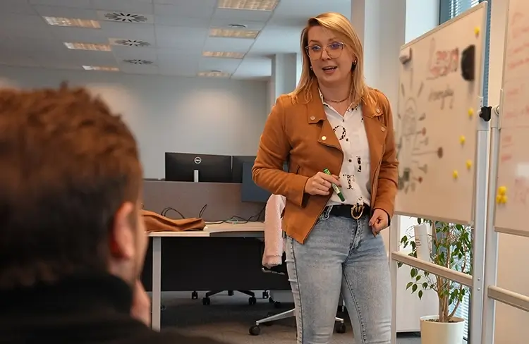 female employee conducting an office meeting in front of a whiteboard