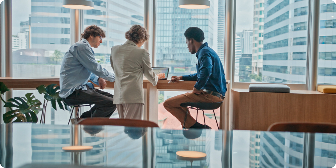 Three persons chatting next to a window
