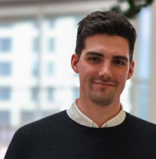 man smiling at camera in shirt and jumper