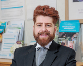 Man in black suit standing in office setting
