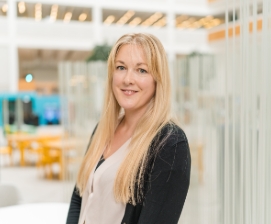 Woman standing and smiling in bright office
