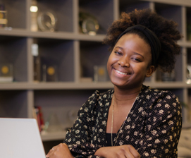 Woman smiling infront of laptop