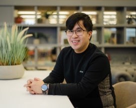 Smiling man in glasses sitting at a desk