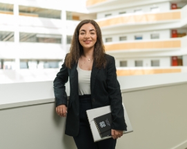 Professional woman holding a laptop and notebook