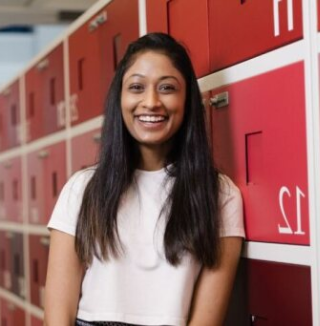 Smiling woman standing near red office lockers.