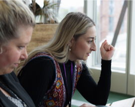 Two colleagues reviewing documents in a meeting room.