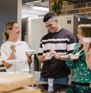 people laughing and eating together indoors