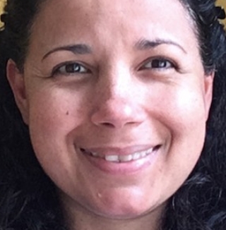 Smiling woman with curly hair and yellow background.