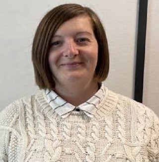 Smiling woman in sweater at Biggleswade office.