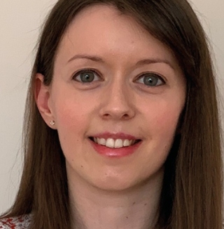 Woman smiling with straight brown hair.