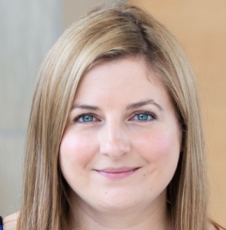 Smiling woman with blonde hair in office setting.