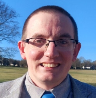 man with glasses smiling at camera