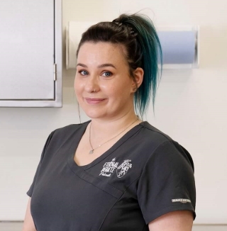 Woman in uniform standing in a clinical workroom.