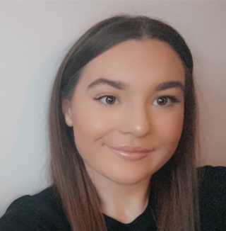 Woman smiling with straight brown hair.