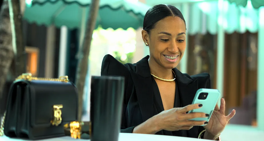 Woman smiling while looking at a mobile phone