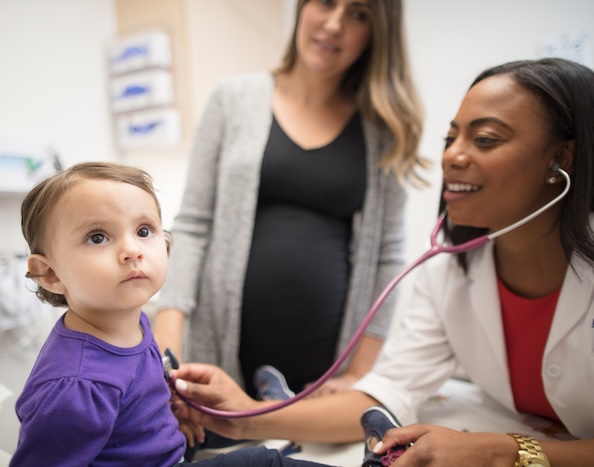 Doctor checking a child's heartbeat