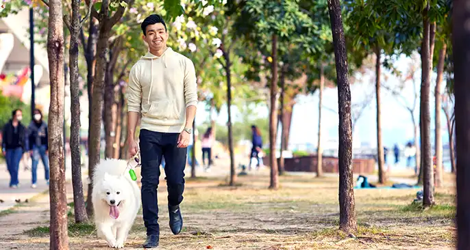 A man walks his dog, enjoying a well-earned break from work.