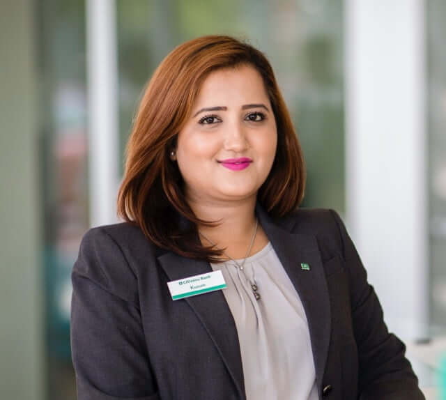Indian female employee wearing a dark suit jacket with a name tag