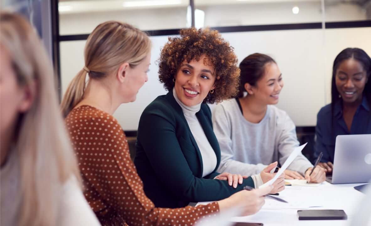 People seating in a conference room, speaking to one another