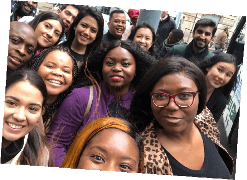 A group of employees pose for a selfie outside