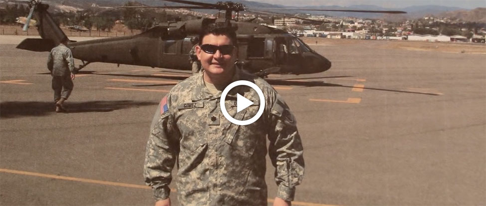 Military guy with a helicopter in the background.