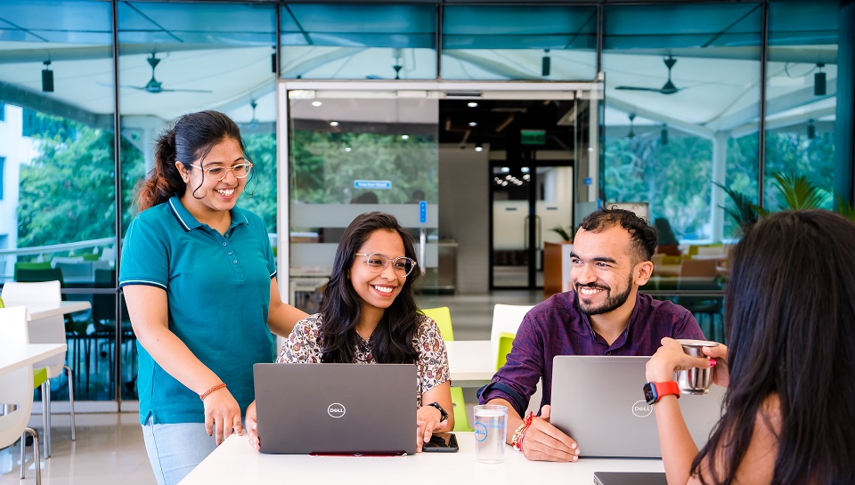 Man and 2 women looking at laptops