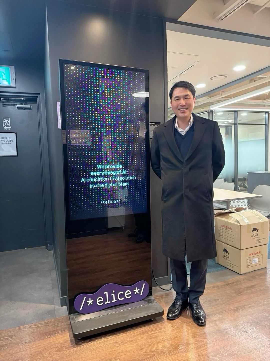 Byungki next to an Elice sign