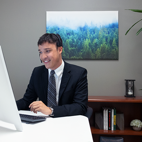 Man at computer with telephone headset on