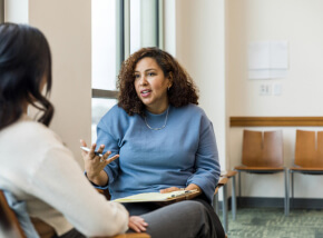 two people conversing in a therapy setting