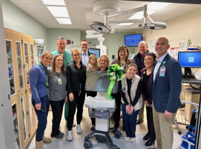 group photo of Trios Health team with new medical machine
