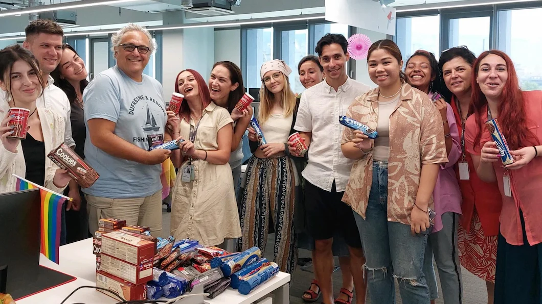 TTEC Athens team holding cookies and freebies.