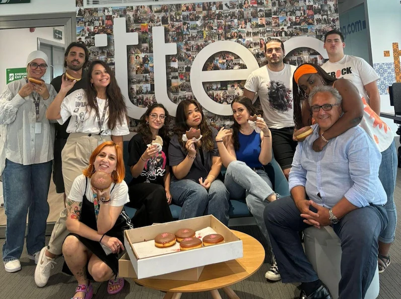 TTEC Greece employees posing for a picture while holding donuts.