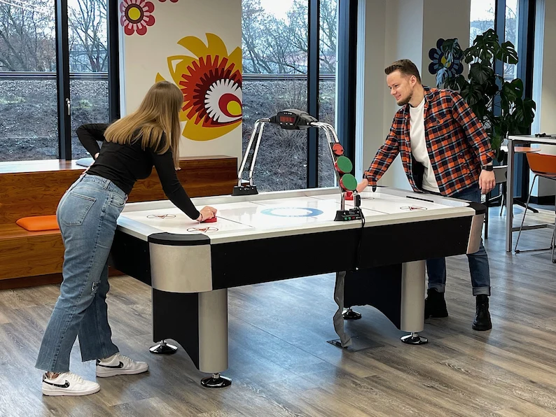 Two TTEC employees playing table top hockey.
