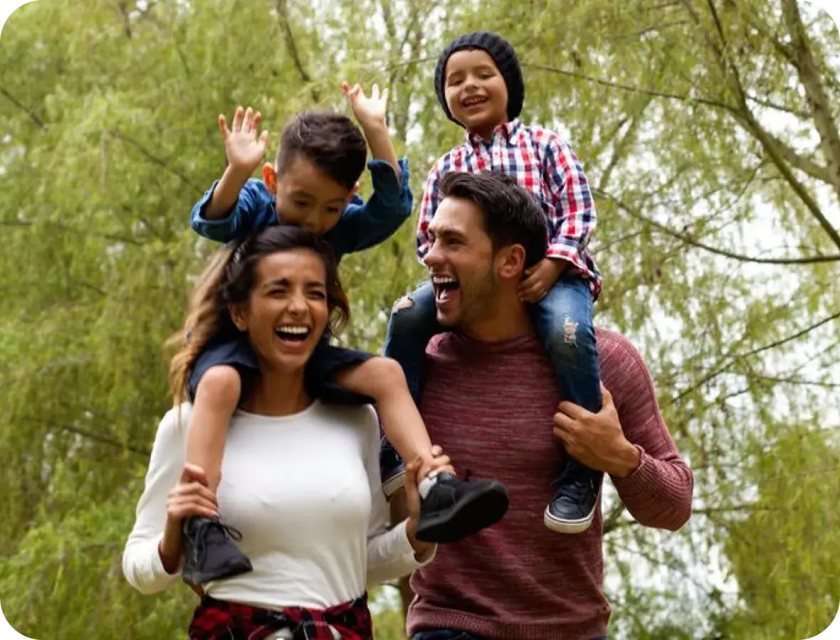 Two parents giving their kids a piggy back ride.