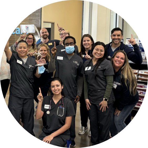 Group of smiling veterinary staff posing indoors.