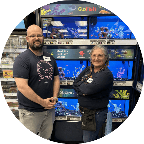 Two employees stand in front of a wall of Aquariums