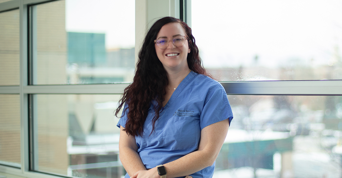 Woman wearing scrubs smiling for the camera