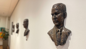 Sculpture of company leaders on wall