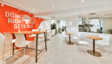 Office seating area with "Doing what's right never gets old" phrase on a wall mural