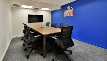 Meeting room with table, chairs and Pato logo on the wall