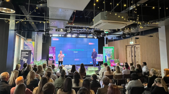 Two team members on stage at marketing meeting presenting strategy